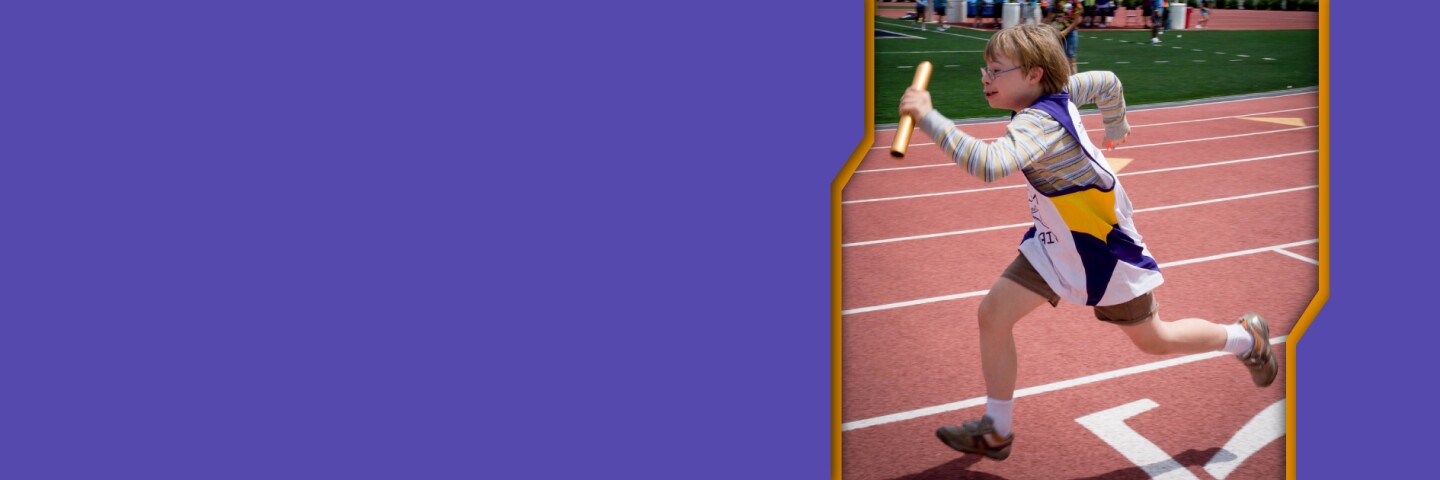 Athlete relay racing on a track with a baton in his hand. 