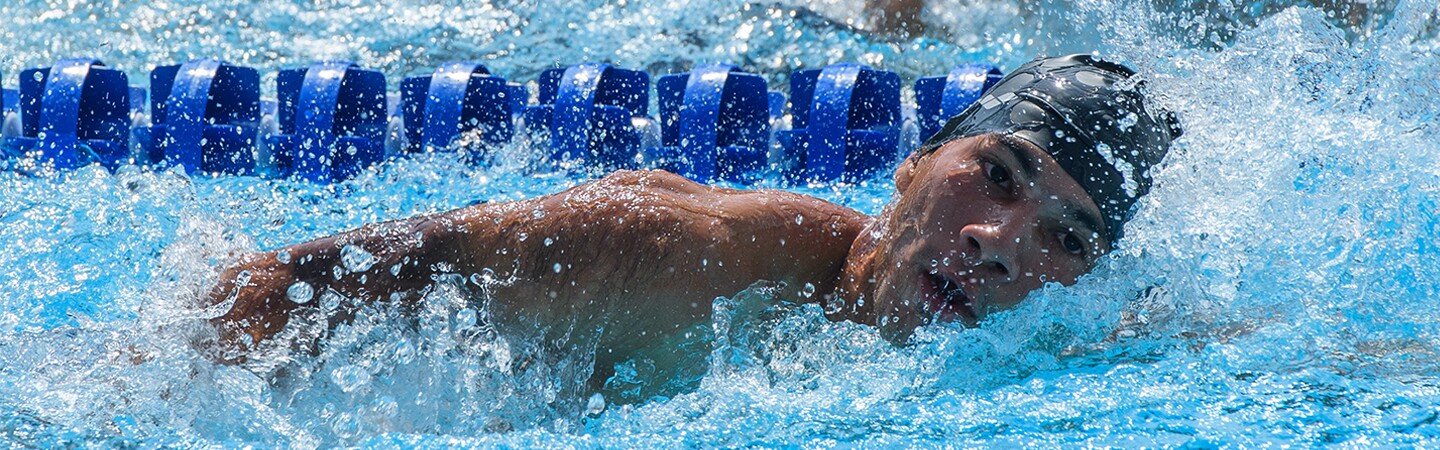 Male swimming in the midst of a race. 