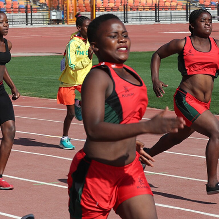 Four women running on a track..