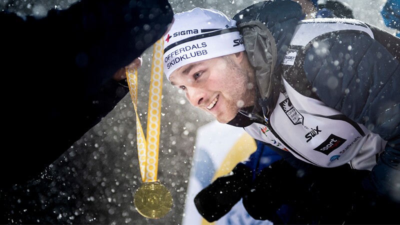 Athlete receiving gold medal and it's snowing. 